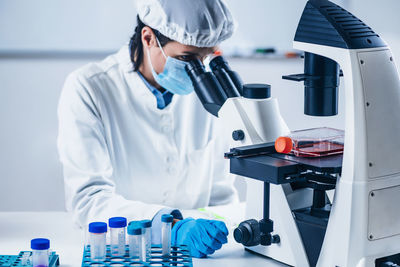 Scientist analyzing cultured artificial meat sample under the microscope in laboratory