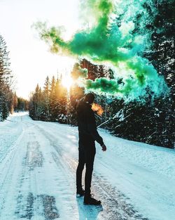 Man standing on snow covered road against sky