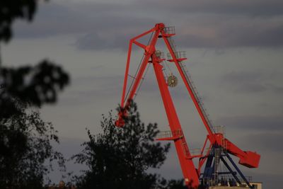 Low angle view of crane at construction site against sky