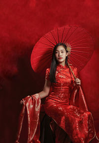 Portrait of a young woman with red umbrella