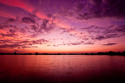 Scenic view of dramatic sky over lake during sunset