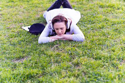 Young woman lying on grassy field