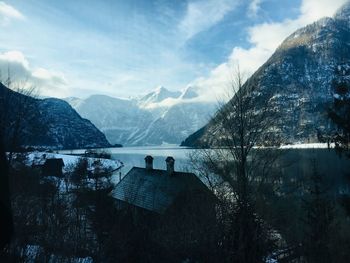 Scenic view of lake by snowcapped mountains against sky