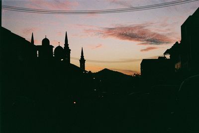 Silhouette buildings against sky at sunset