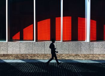 Woman standing by red railing