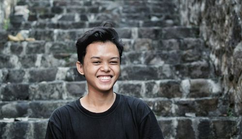 Portrait of smiling teenage boy against steps