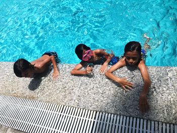 High angle view of siblings swimming in pool