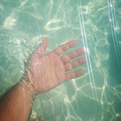 High angle view of person legs in swimming pool