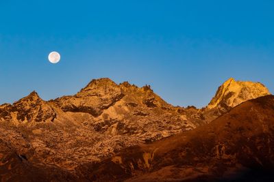 Low angle view of mountains against clear blue sky