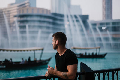 Young man looking at city buildings