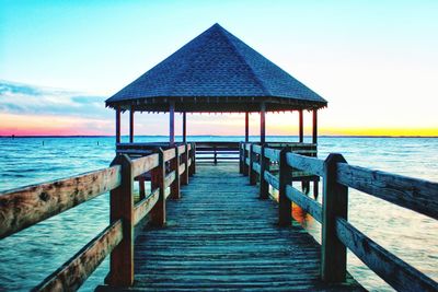 Wooden pier on sea against sky