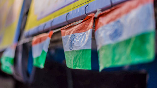 Close-up of multi colored flags hanging against wall