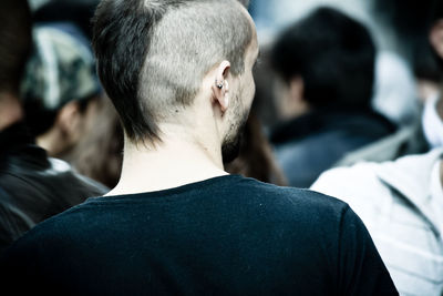 Rear view of hipster with hairstyle in crowd