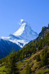 Scenic view of snowcapped mountain against blue sky