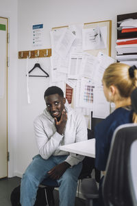 Teenage male patient explaining female healthcare worker during visit at hospital