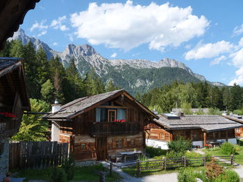 Houses amidst trees and buildings against sky