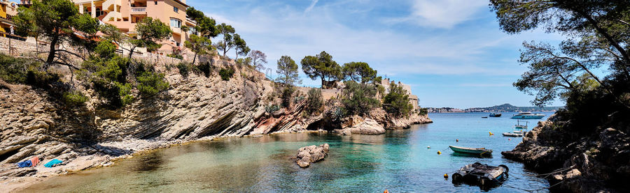 Panoramic view of rock formation by sea against sky