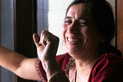 Close-up of cheerful woman with clenched fist