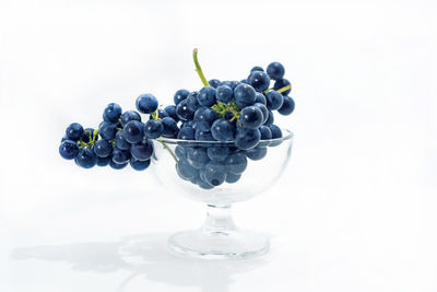 Close-up of grapes on table against white background