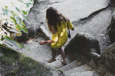 Rear view of woman on rock