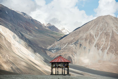 Built structure on snow covered mountain against sky