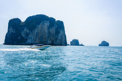 Scenic view of rock formation in sea against clear sky