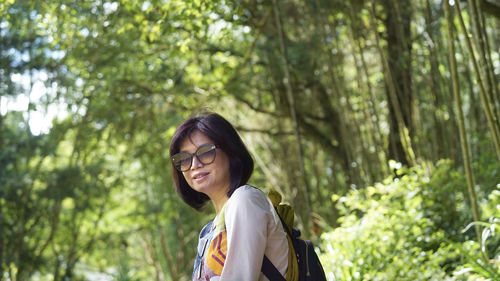 Portrait of smiling young woman against plants