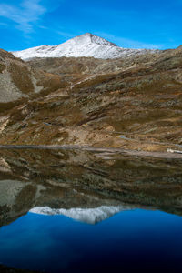 Scenic view of lake and mountains against blue sky