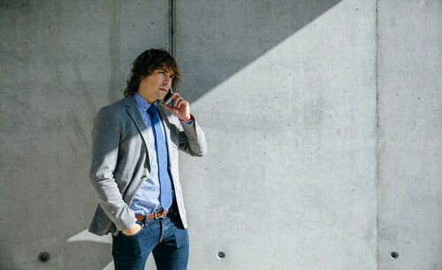 Full length portrait of man standing against wall