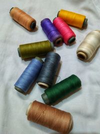 High angle view of colorful thread spools on textile