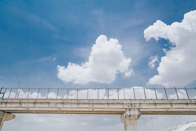 Low angle view of bridge against cloudy sky
