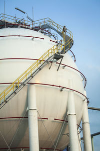 Low angle view of gas tank against sky