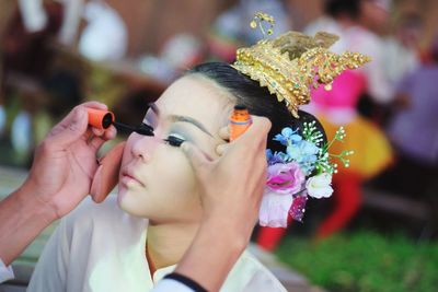 Cropped image of artist applying make-up on young woman