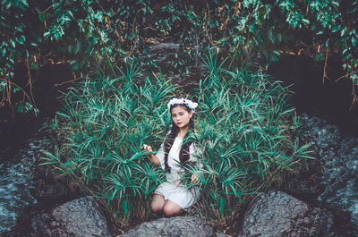 Portrait of young woman sitting on land