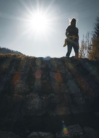 Low angle view of woman standing on rock