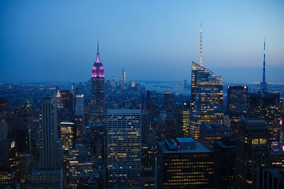 Illuminated buildings in city at dusk