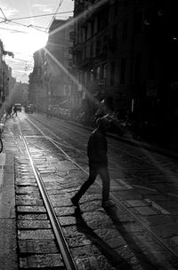 Full length of man on railroad tracks in city