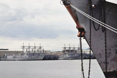 Ships at harbor against sky