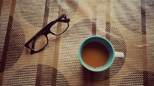 Directly above shot of tea and eyeglasses on table
