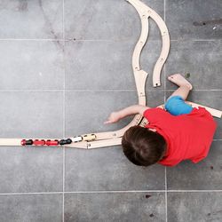 Directly above view of boy playing with toy train on floor