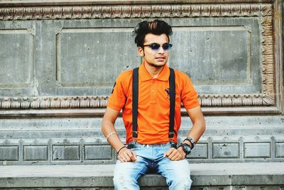 Young man wearing sunglasses against building