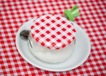 High angle view of sugar in bowl covered with fabric on table