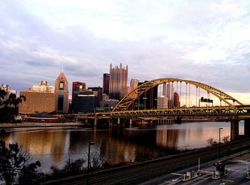 Fort duquesne bridge over allegheny river by cityscape against sky