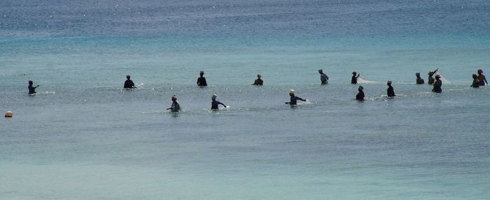 People swimming in sea against sky