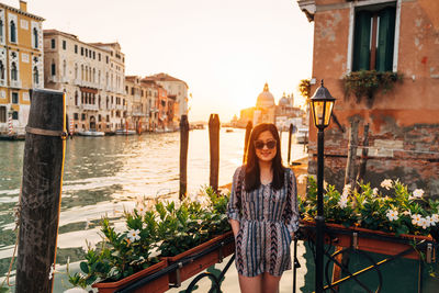 Portrait of woman standing by canal against santa maria della salute