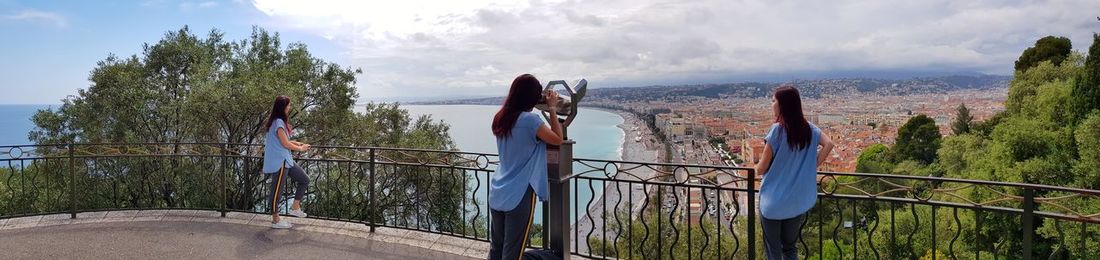 Multiple image of woman standing by coin-operated binoculars observation point