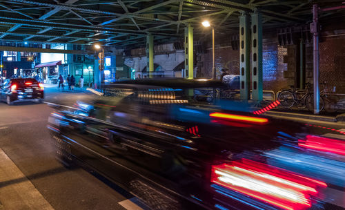 Cars on illuminated street at night