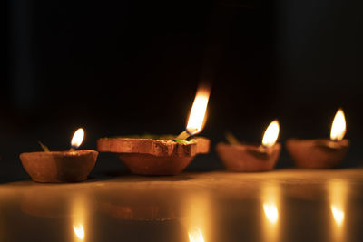 Five diyas kept in a row, celebrating diwali in india.