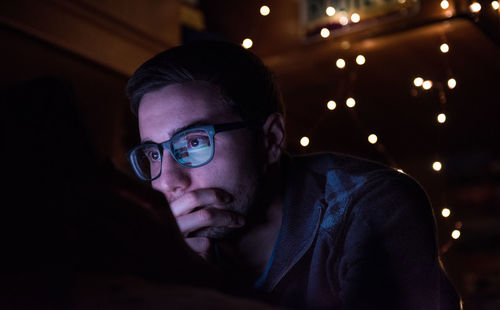 Close-up portrait of man with illuminated light painting at night