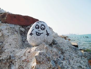 Anthropomorphic face on pebble by sea